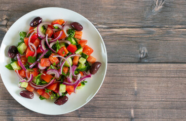 Salad of tomatoes, cucumbers, bell peppers, red onion and olives with olive oil
