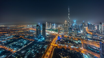 Fototapeta na wymiar Aerial panorama of tallest towers in Dubai Downtown skyline and highway night timelapse.