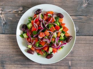 Vegan salad of vegetables, onion, parsley and kalamata olives with olive oil