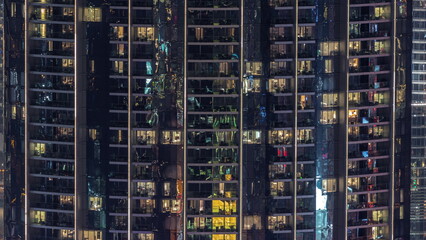 Fototapeta na wymiar Windows in apartments of a high class building at night timelapse