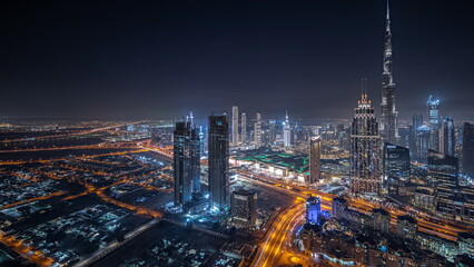 Obraz premium Panorama showing aerial view of tallest towers in Dubai Downtown skyline and highway night timelapse.