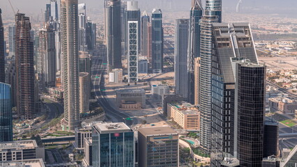 Downtown skyline with modern architecture form above all day timelapse. Aerial view of Dubai business bay towers.
