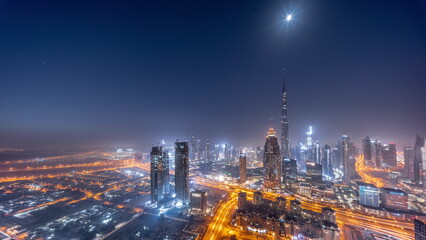 Fototapeta na wymiar Aerial view of tallest towers in Dubai Downtown skyline and highway night to day timelapse.