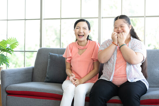 young teenage girl and her mother looking and surprised at something on sofa