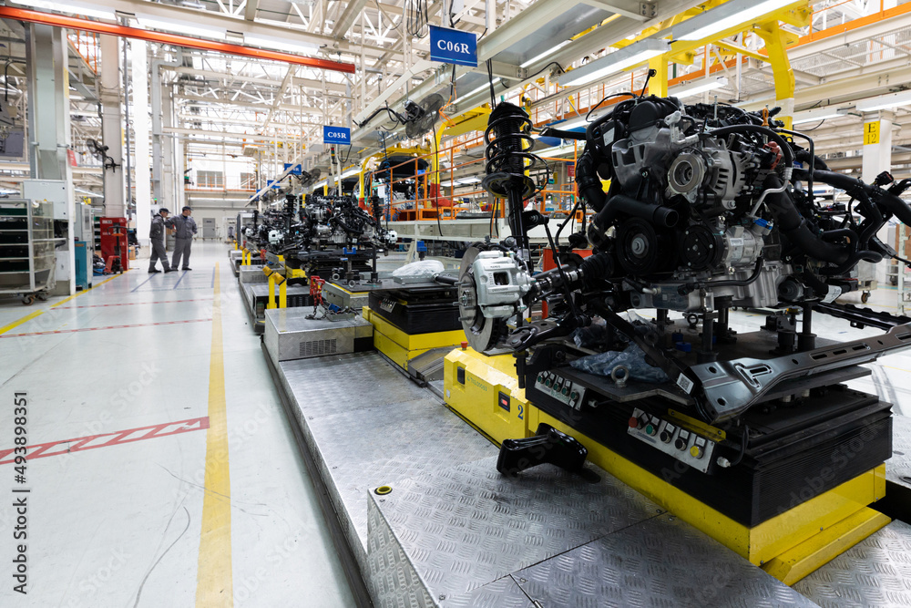 Wall mural Photo of car bodies are on assembly line. Factory for production of cars. Modern automotive industry