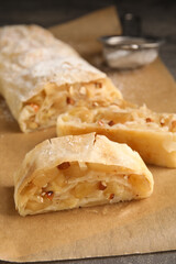 Delicious apple strudel with almonds on parchment, closeup