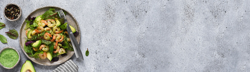 Mix salad with shrimp and avocado on the kitchen table, top view.