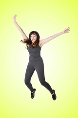 Fototapeta na wymiar Happy woman wear sportswear while jump on studio