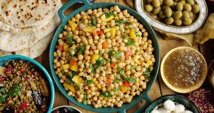 Chickpeas with vegetables and herbs. Traditional vegan dishes on the table, dates, cheese sauces