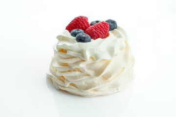 Pavlova cake with berries on white background