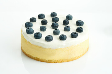 Whole cheesecake cake with blueberries on a white background