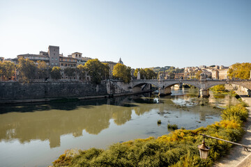 Fototapeta na wymiar Landscape of Tiber river and green surroundings at sunny day in Rome. Traveling Italy