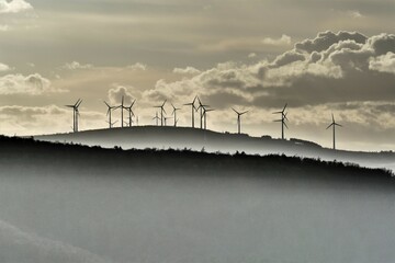 Windräder am bergigen Horizont im dunstigen Abendlicht