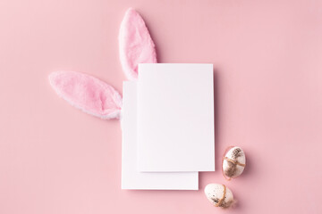 Easter mockup with decorative rabbit ears and eggs, poster on pink background