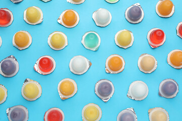 Tasty bright jelly cups on light blue background, flat lay
