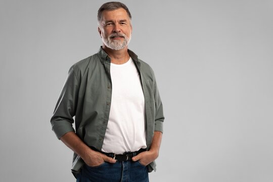 Portrait of smiling mature man standing on white background