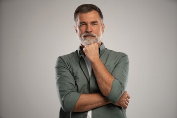 Portrait of smiling mature man standing on white background