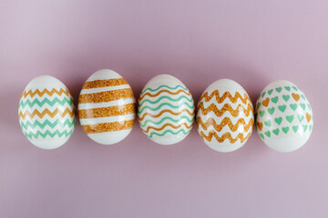 Easter eggs in pastel colors with a pattern on a pink background.