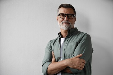 Portrait of smiling mature man standing on white background