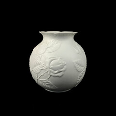 antique white porcelain vase in on a black isolated background. antique ceramic vase with stucco