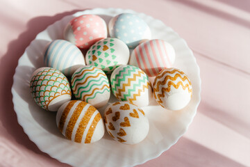 Easter eggs in pastel colors with a pattern lie on a white plate