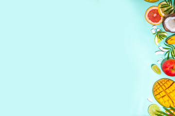 Summer fruits background. Various tropical fruits on turquoise background - mango, coconut, apples, avocado, lemon, orange, grapefruit, pineapple, with palm leaves. Colorful frame, banner flatlay