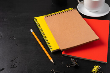 Three notepads on a black table close up