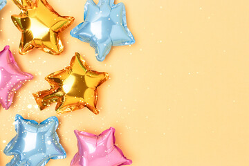 Multicolored star balloons with place for text on a golden background.