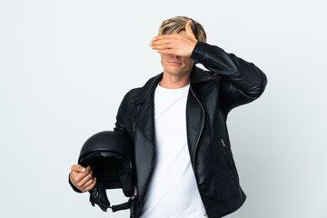 English man holding a motorcycle helmet covering eyes by hands. Do not want to see something