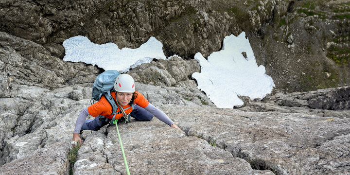 Woman with backpack climbing mountain