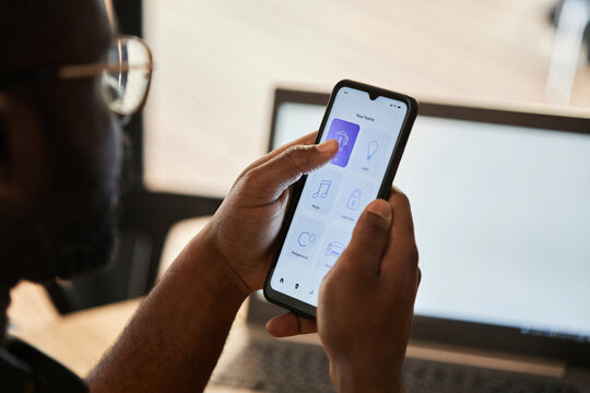 Young man using home automation app on smart phone