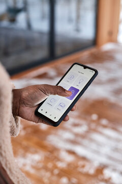 Man locking door of house using app on smart phone