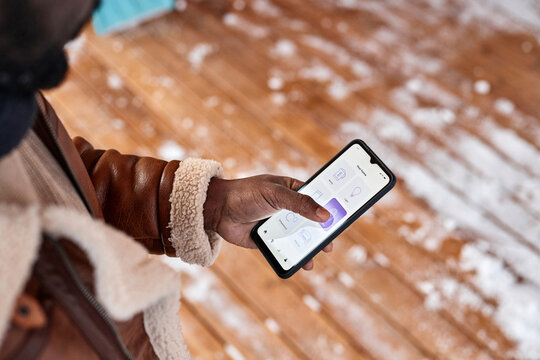 Man locking door of house through home automation app on smart phone