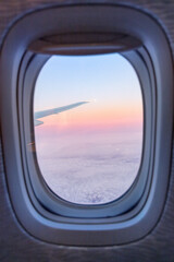 View from airplane window at sunset with cloudy sky