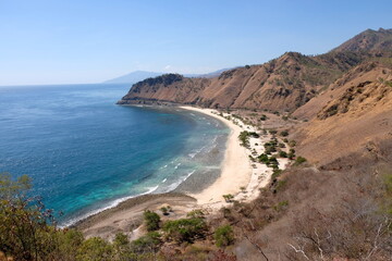Fototapeta na wymiar The stunning curved white sandy beach and turquoise blue ocean of Cristo Rei back beach in Dili, Timor Leste