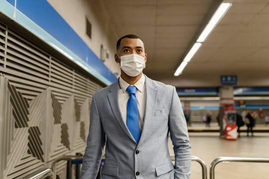 Businessman wearing protective face mask standing at train station