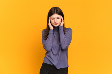 Young Ukrainian girl isolated on yellow background with headache