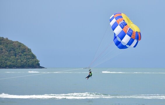 People enjoying parasailing near the water 