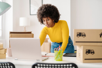 Young entrepreneur using laptop standing at table