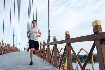 Asian young handsome active sport man running on street in public park. 