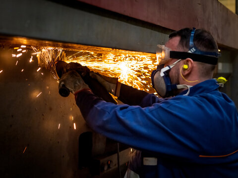 Un ouvier &agrave; l'usine avec une disqueuse