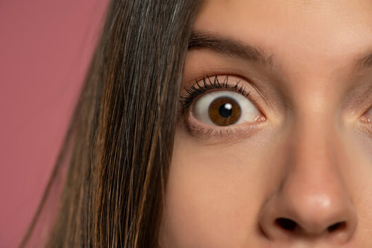 The wide open brown eye of a young woman: a concept of surprise and close observation