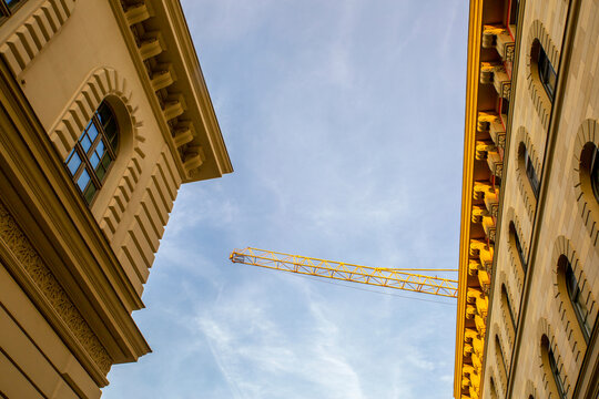 Germany, Bavaria, Munich, Low angle view of industrial crane standing over stucco cornices