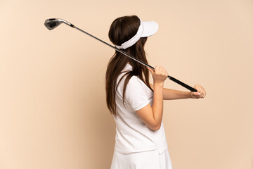 Young Ukrainian girl isolated on beige background playing golf