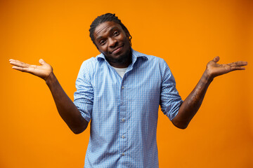 Young afrcian man isolated on yellow background showing helpless gesture