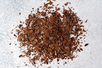 Grated dark chocolate shavings on gray background