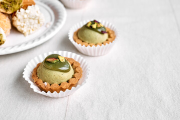 Delicious tartlets dessert assorted pastries. Mini tartlets with pistachio cream filling. Close Up of delicious pastry sweets pies.