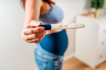 A woman keeps a positive pregnancy test. Focus on the test