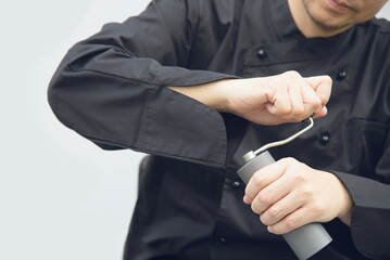 Asian barista is using hand coffee bean grinder prepare to make hot coffee
