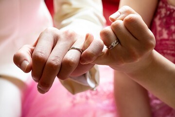 Left hands of men and women tied with a tight bond